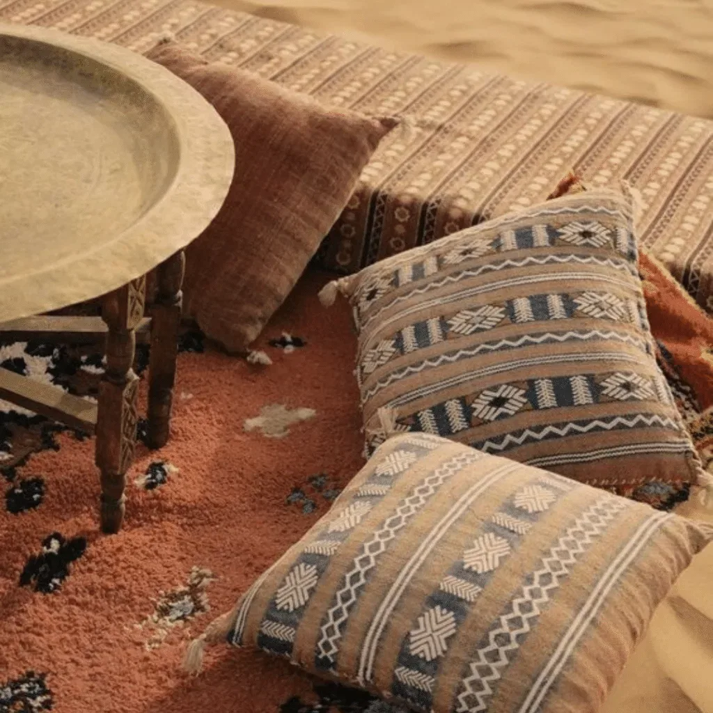 Handwoven Moroccan cushions and a brass tray on a textured rug