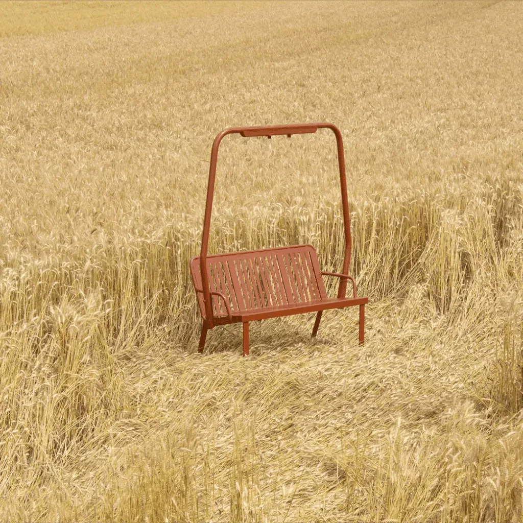 Refurbished red alpine chairlift bench standing in a wheatfield